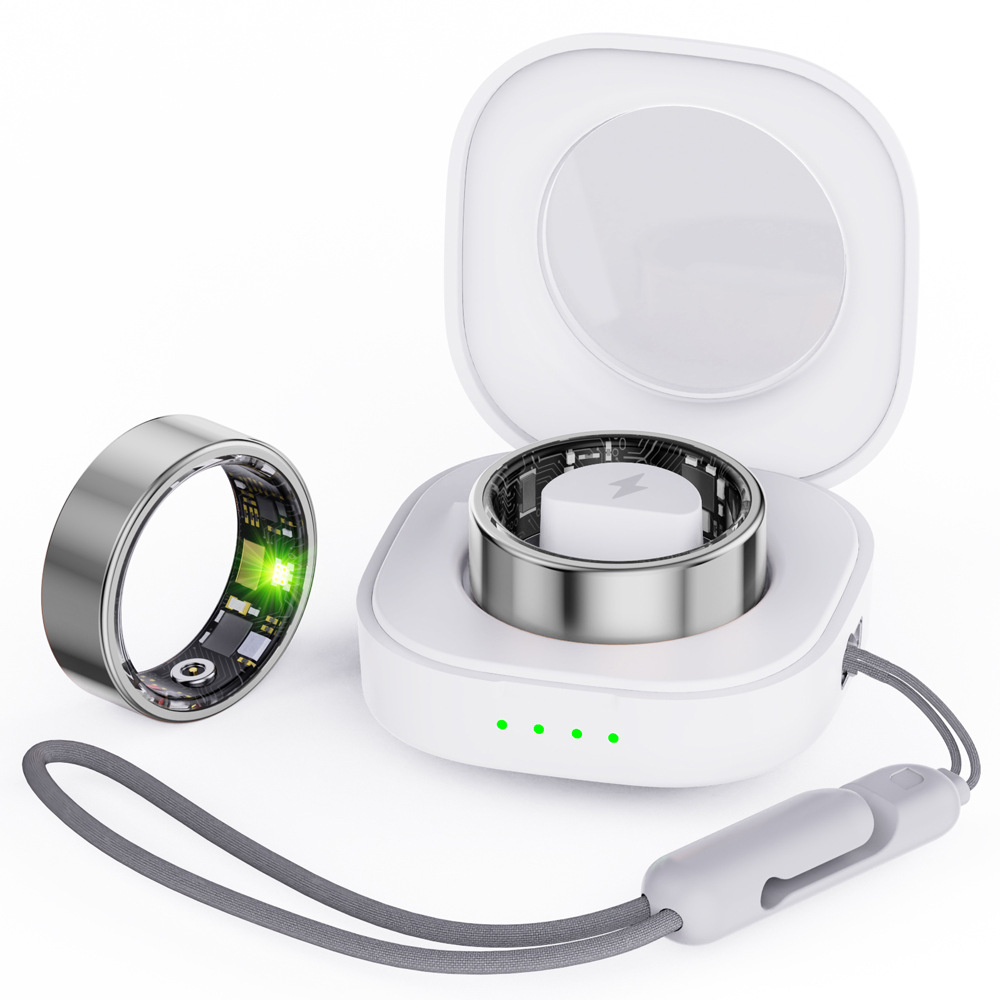Ein silberner Ring mit grüner LED liegt neben einem weißen Ladekoffer, in dem ein Ring steckt.