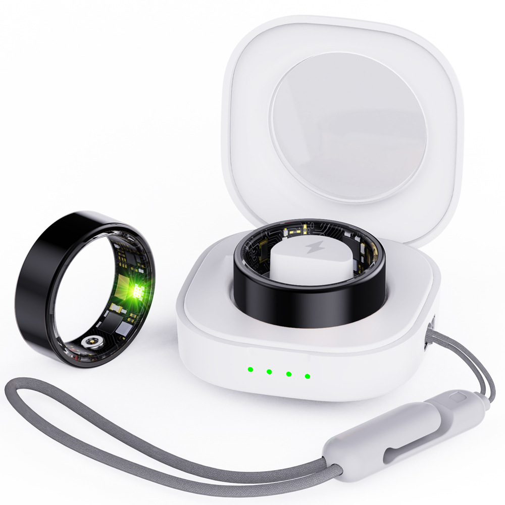 Schwarzer Ring mit grüner LED neben weißem Ladecase mit Ring darin.