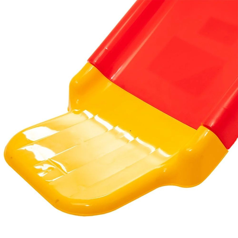 Nahaufnahme einer roten und gelben Rutsche mit Rippenmuster am Ende.