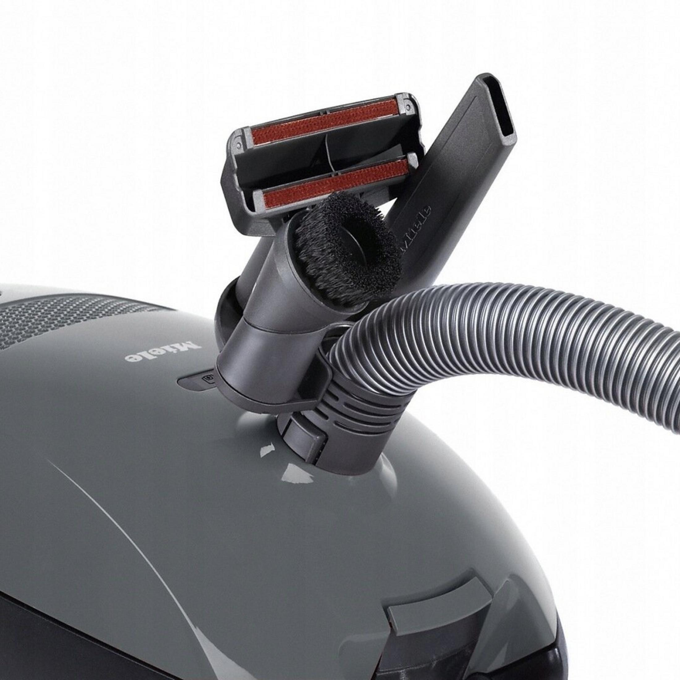 Aspirapolvere Miele grigio con spazzola, tubo e accessorio per fessure.