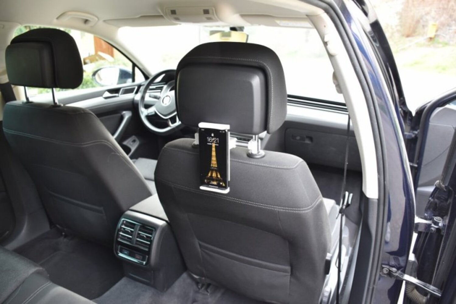 Smartfon jest przymocowany do tyłu zagłówka samochodowego.