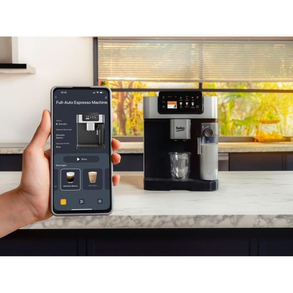 Una mano tiene uno smartphone con un'app per macchina da espresso. Accanto c'è una macchina da caffè.