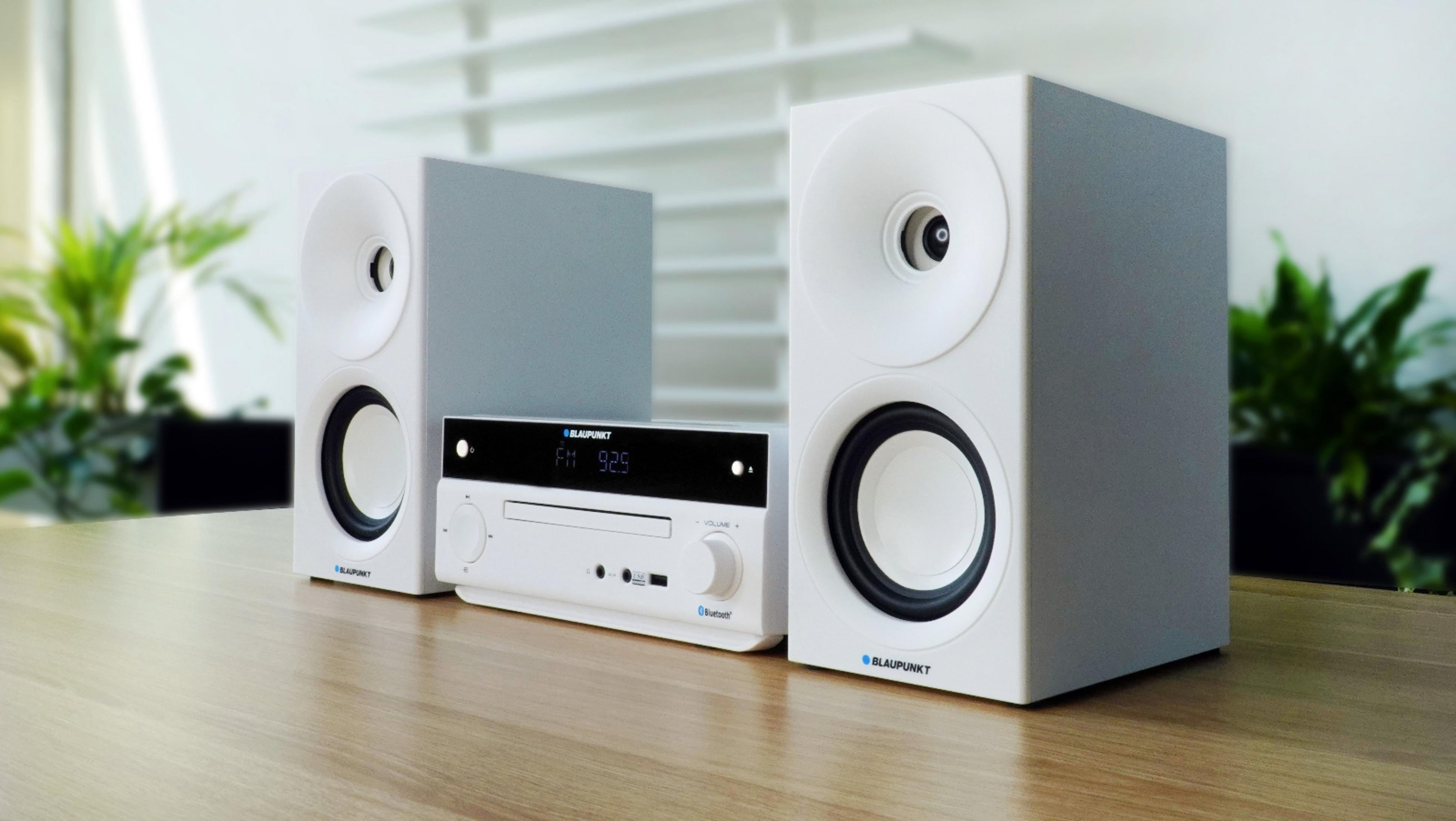 Un sistema stereo Blaupunkt bianco con lettore CD e altoparlanti è su un tavolo di legno.