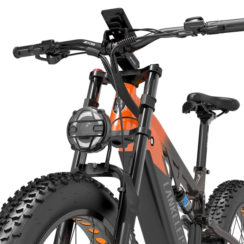 Bicicleta eléctrica naranja con neumáticos anchos, horquilla y faro.