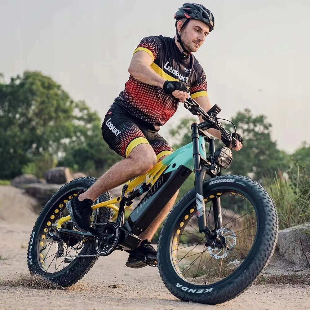 Un hombre monta una bicicleta eléctrica amarilla con neumáticos anchos en un camino.