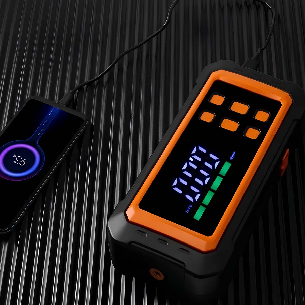 Ein Smartphone mit 93% Akku neben einem orangefarbenen digitalen Reifendruckprüfer.