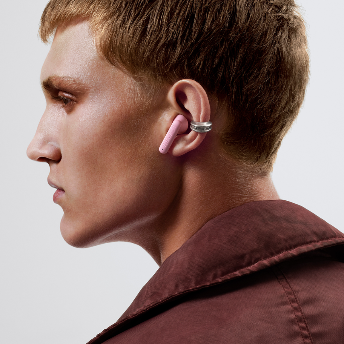 Man with pink earbud and silver ear cuff.