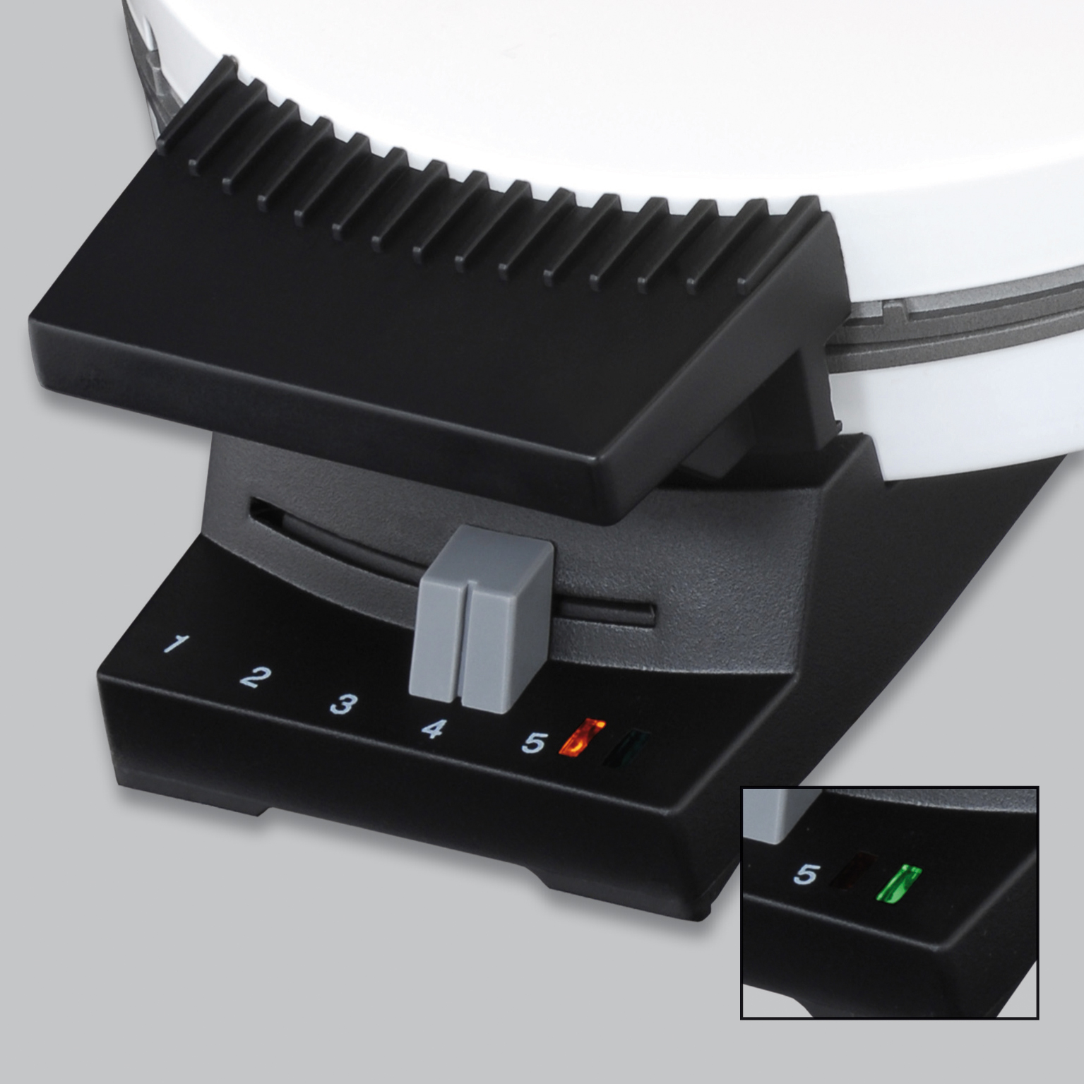 Primer plano del control de una wafflera negra con números e luces.