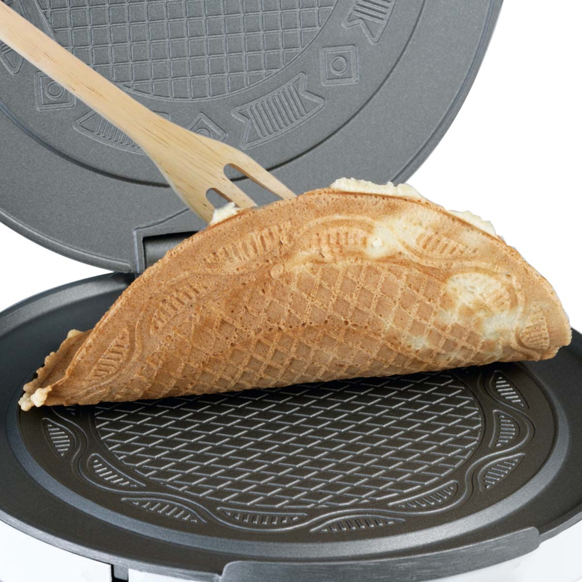 Drewniany widelec kształtuje złocistobrązowy wafel w gofrownicy.