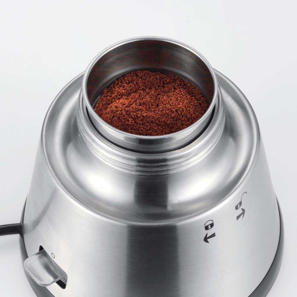 Macinacaffè in acciaio inossidabile con caffè macinato nel contenitore.