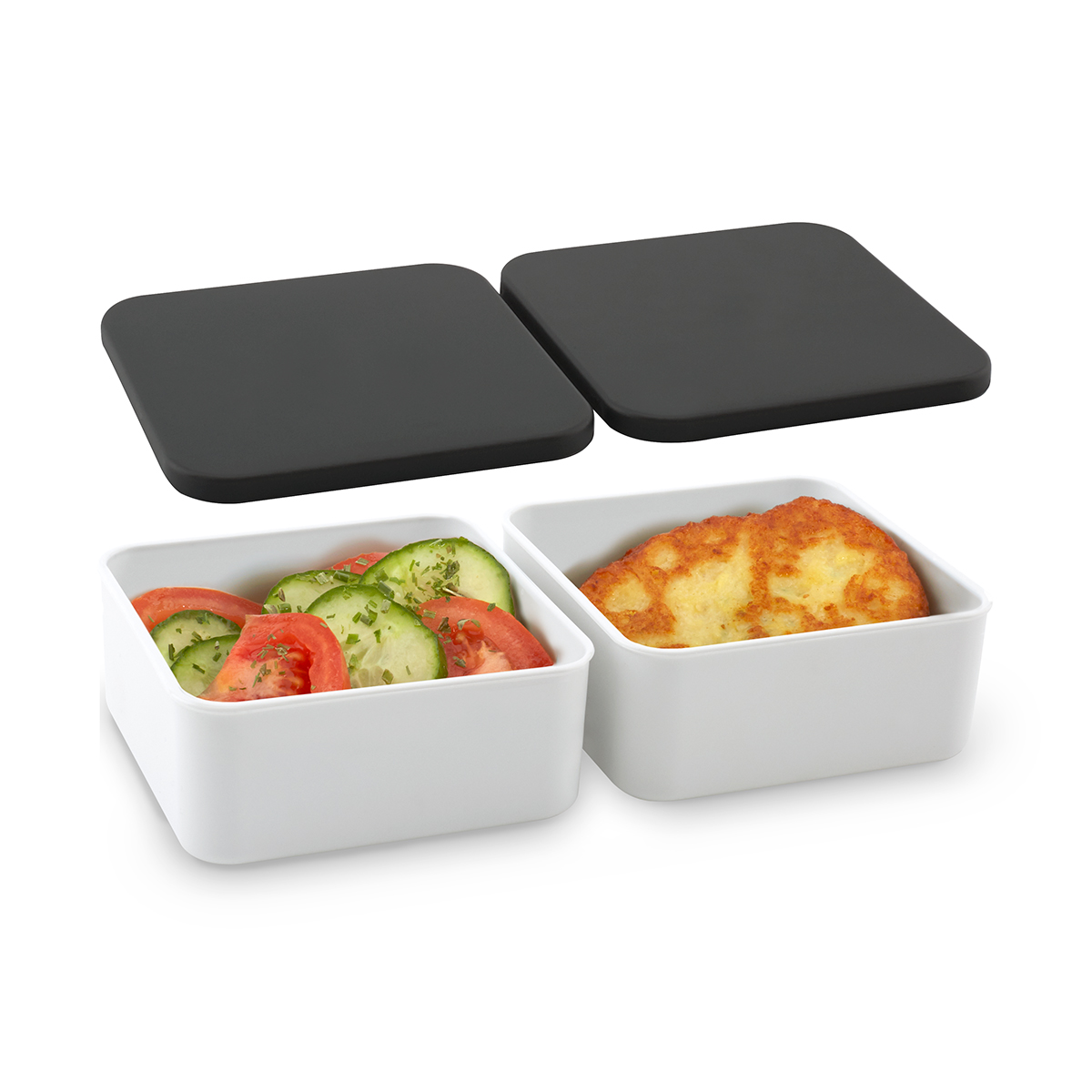 Zwei weiße Behälter mit Salat und gebratenem Essen, zwei schwarze Deckel liegen darüber.