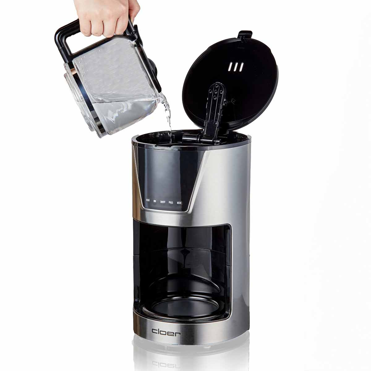 Ręka wlewa wodę ze szklanego pojemnika do ekspresu do kawy.