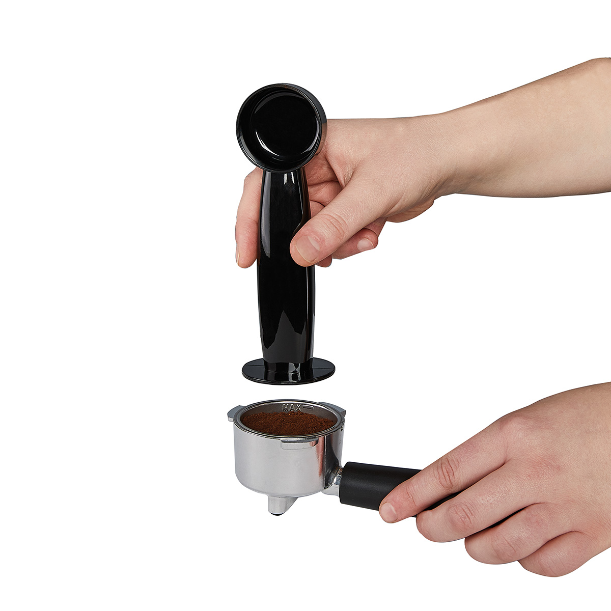 Eine Hand hält einen schwarzen Kaffeepressgriff über einem Siebträger mit Kaffeepulver.