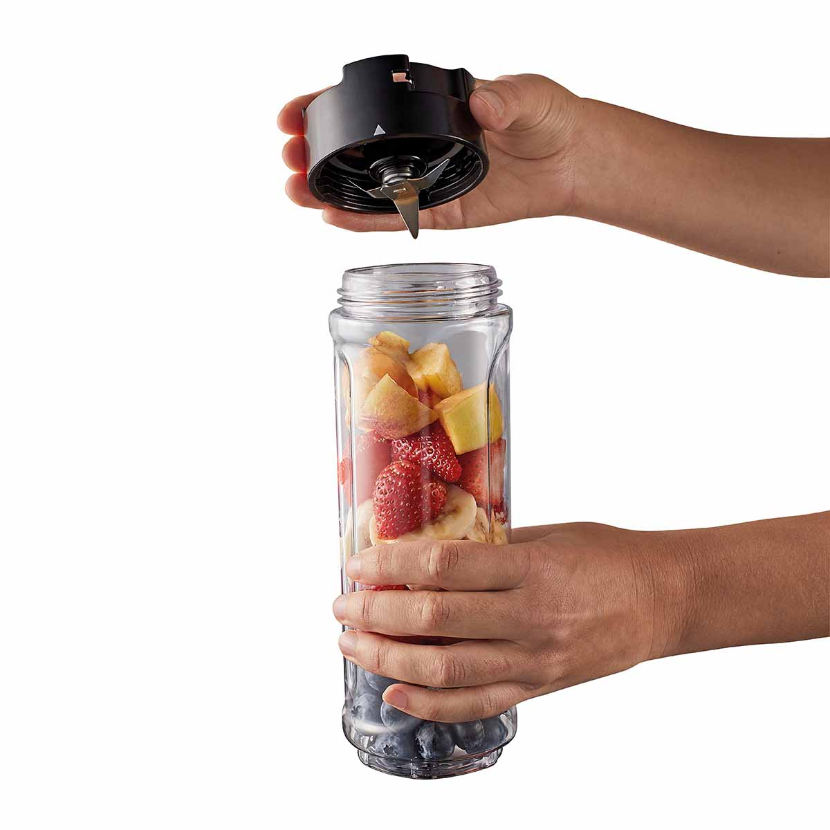 Hände setzen ein Klingenelement auf einen Glasbehälter mit Obst.