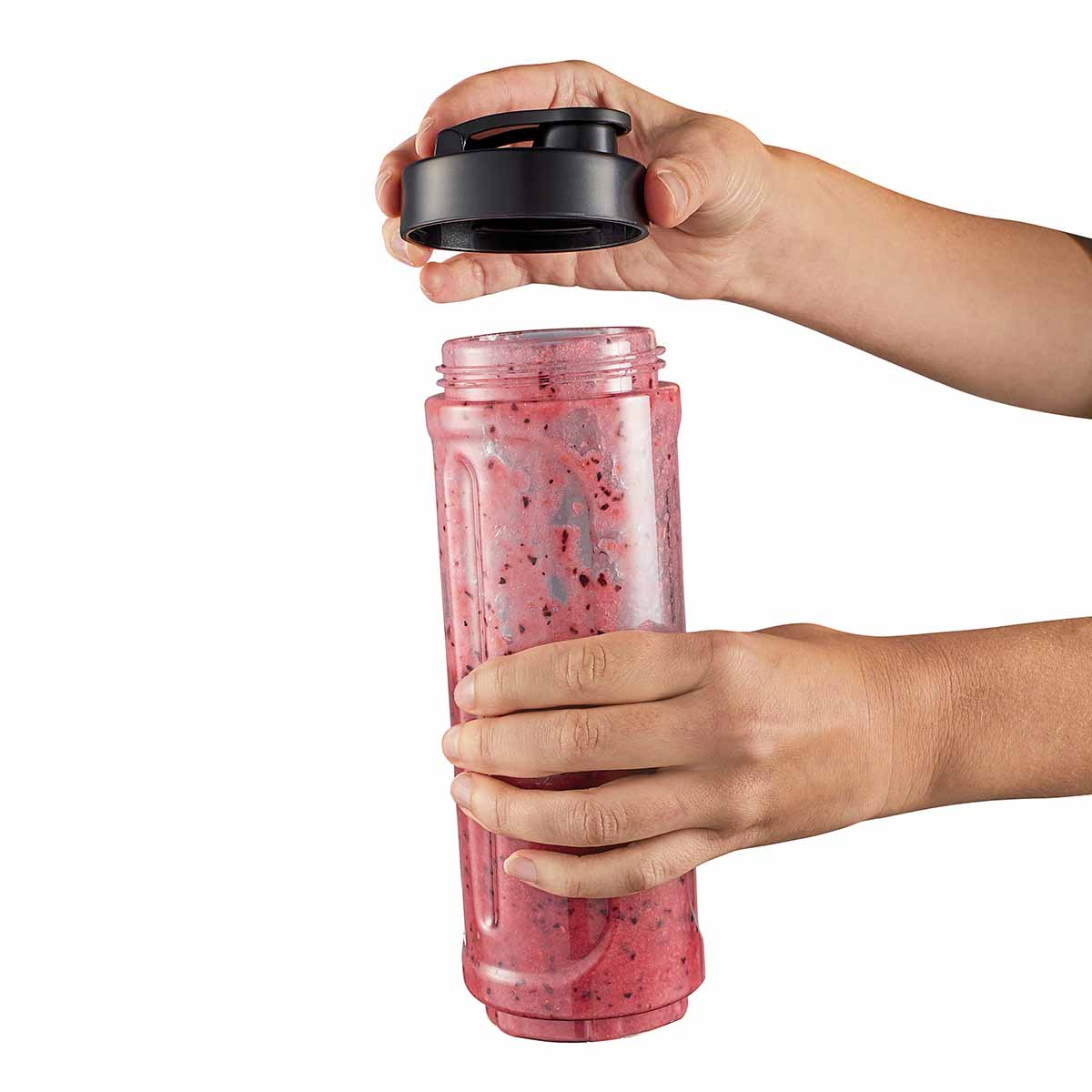 Hände öffnen einen Behälter mit rotem Smoothie, Deckel abgenommen.