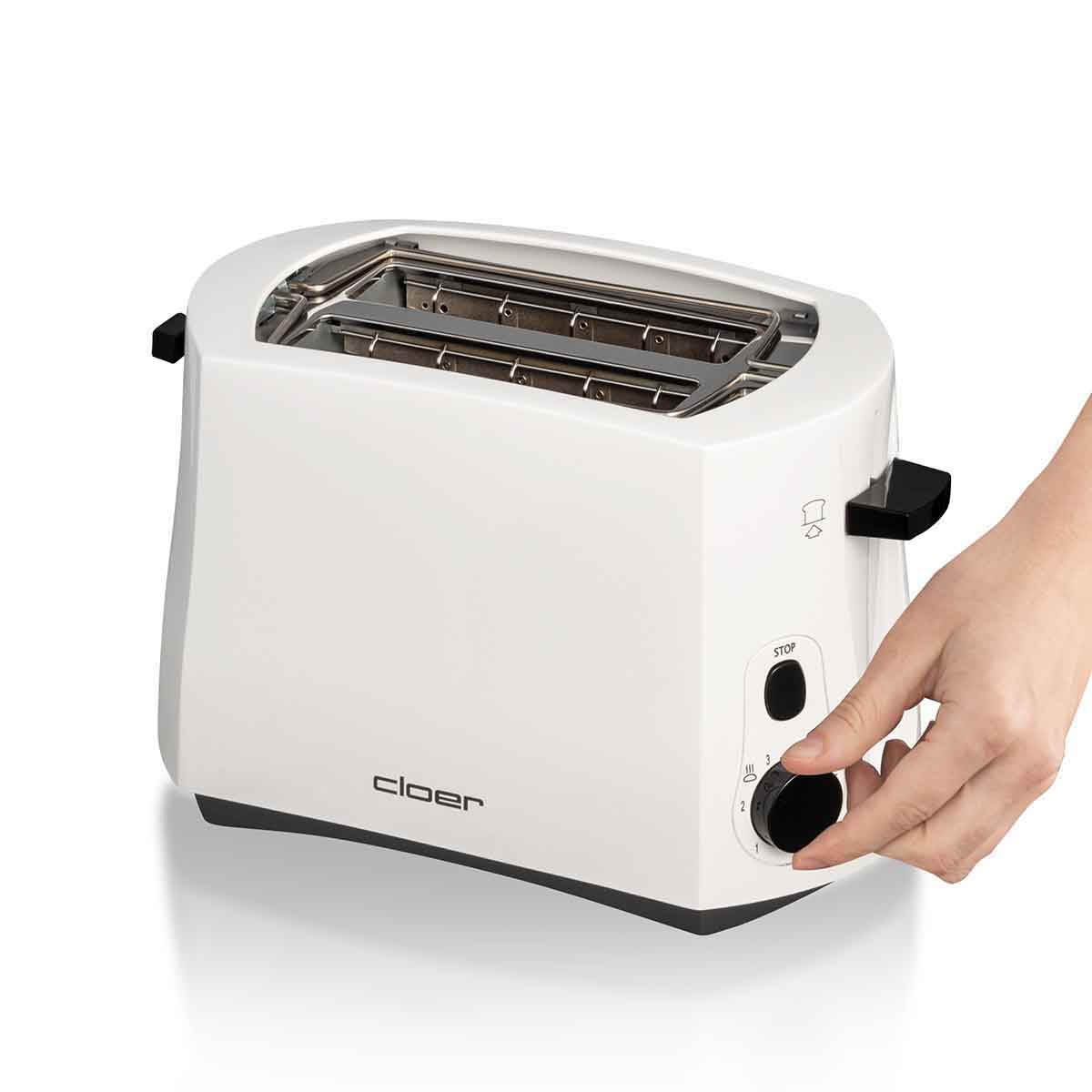 Eine weiße Toaster-Nahaufnahme mit einer Hand, die den Knopf dreht.