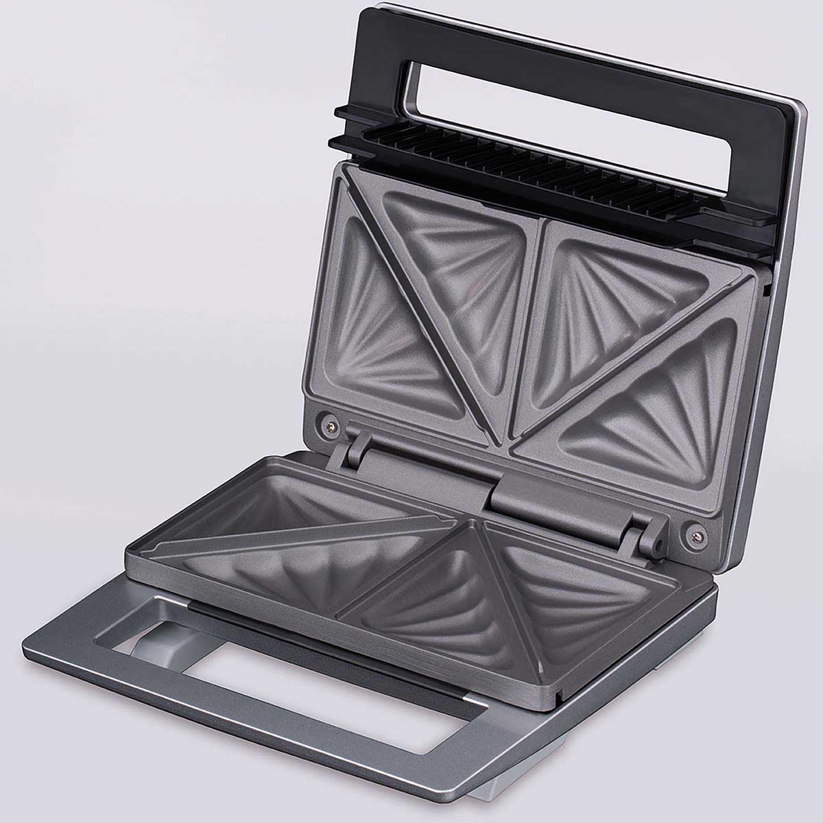 Una sandwichera abierta con cuatro placas calefactoras triangulares, gris.