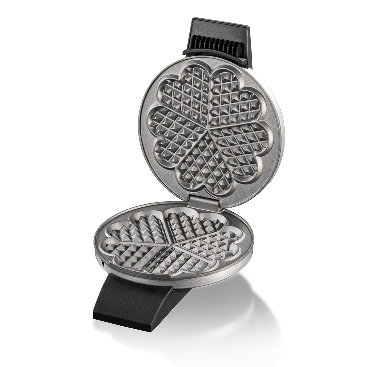 Otwarta gofrownica w kształcie serca z metalowymi płytami na białym tle.