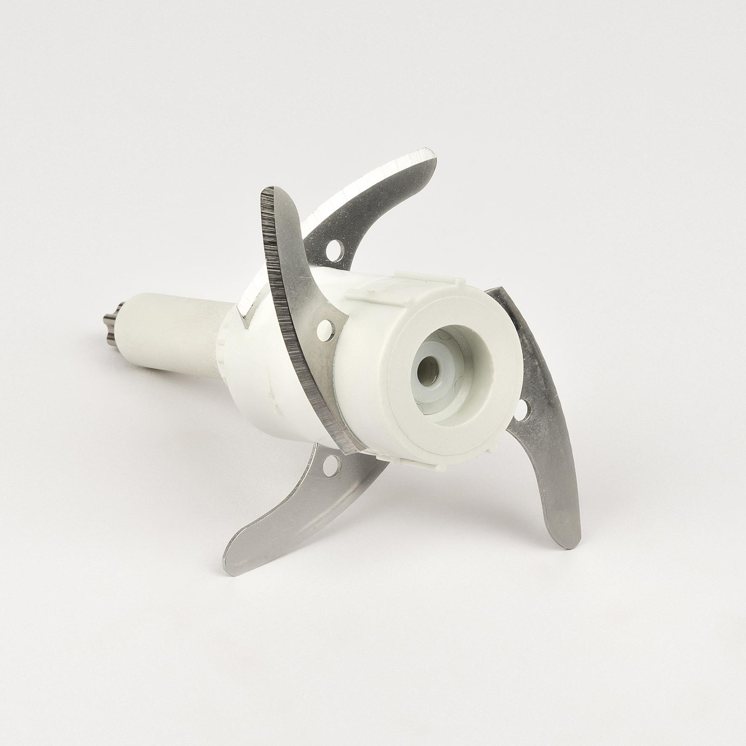 Un accessorio frullatore bianco con quattro lame metalliche affilate su sfondo bianco.