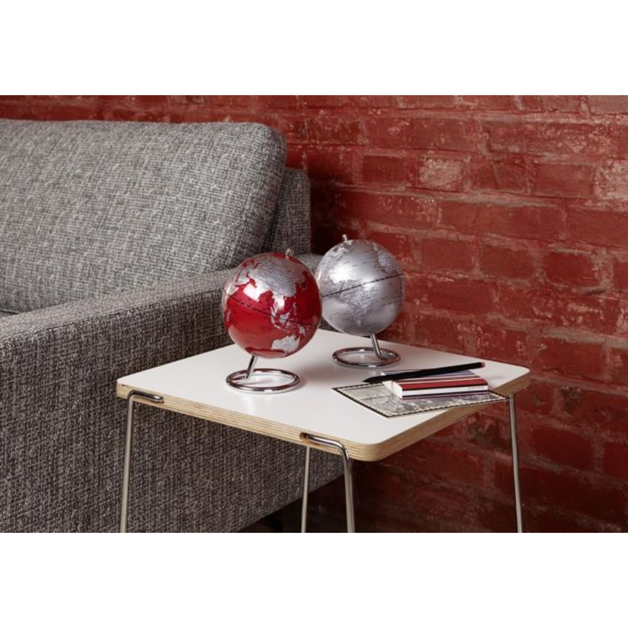 Zwei Globen auf einem Tisch: Rot mit Silber und Silber mit Silber.