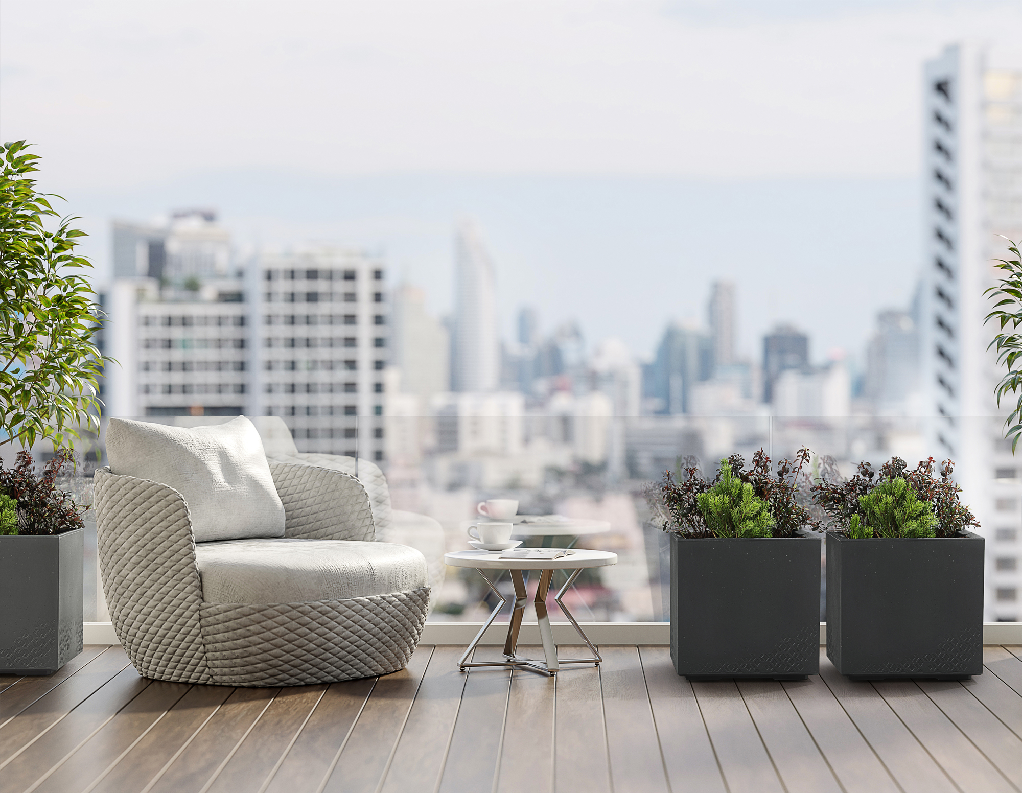 Ein Sessel und ein Tisch auf einem Balkon mit Stadtblick.