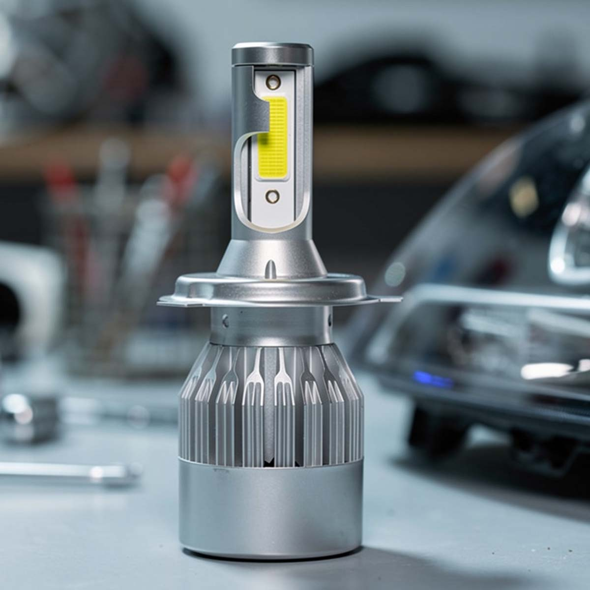 Silberne LED-Lampe mit Kühlkörper und gelbem Licht-Element, nahaufnahme.