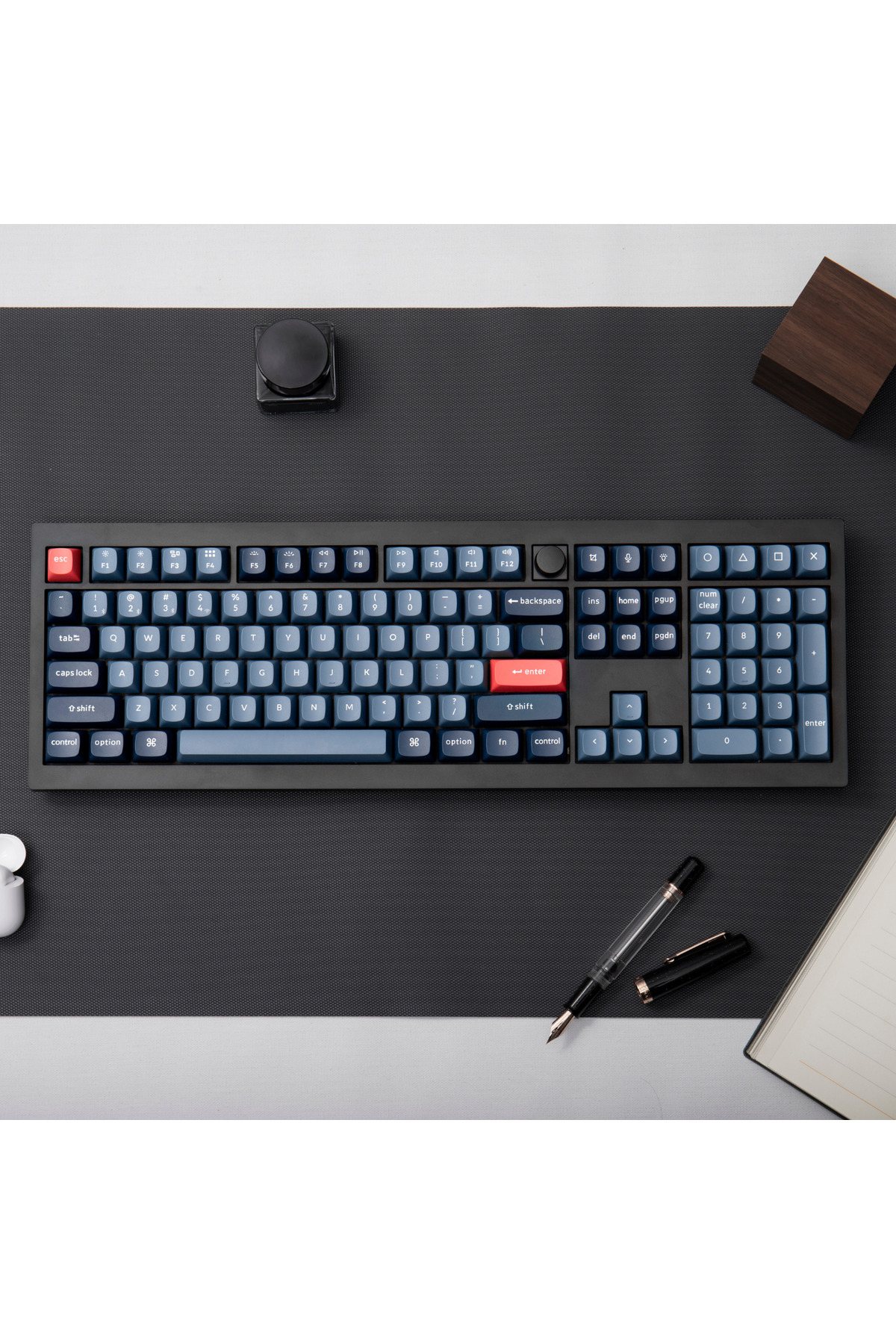 Ciemna klawiatura z niebieskimi klawiszami na szarej macie.