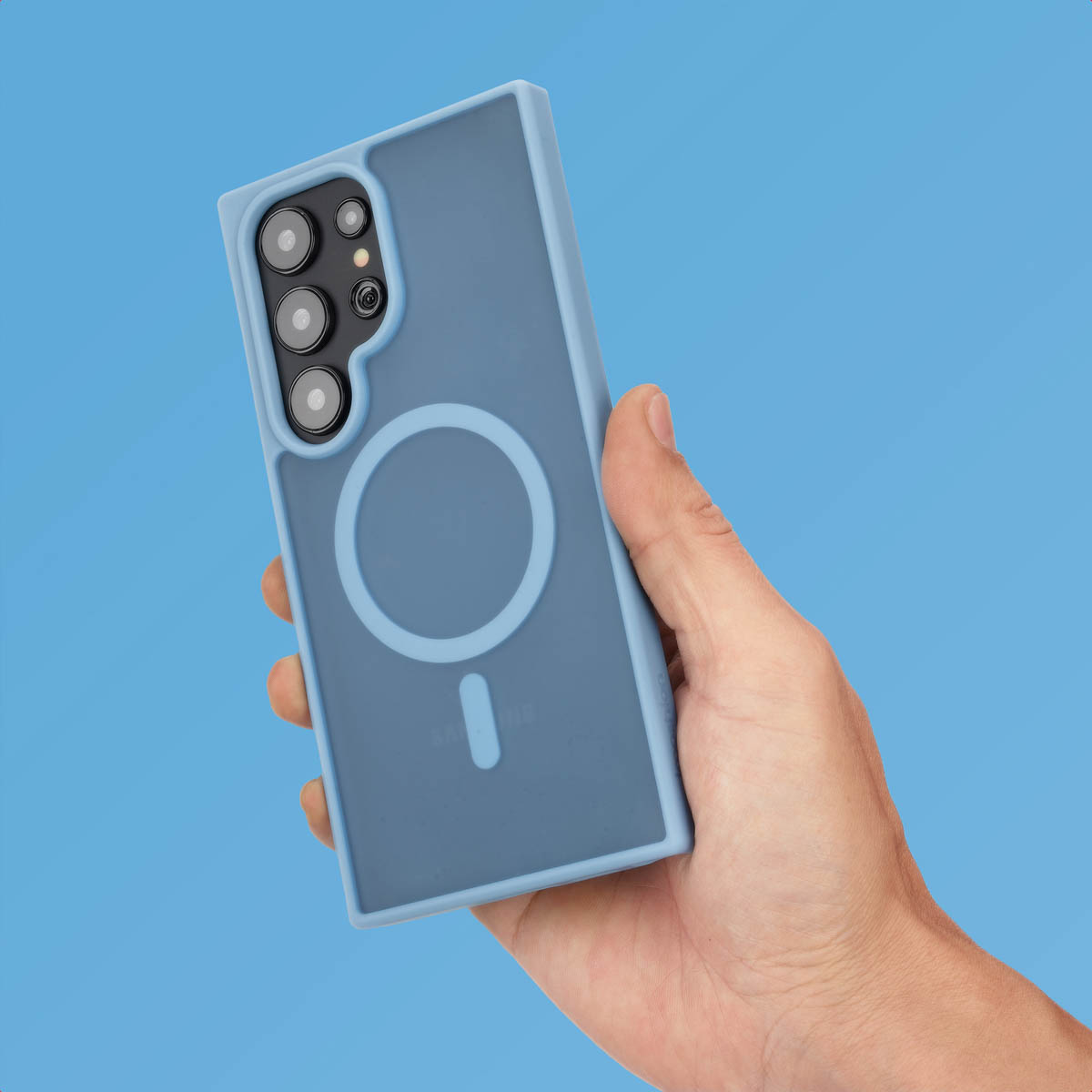 Hand met een blauwe telefoonhoes met camerabobbel en magneetring.