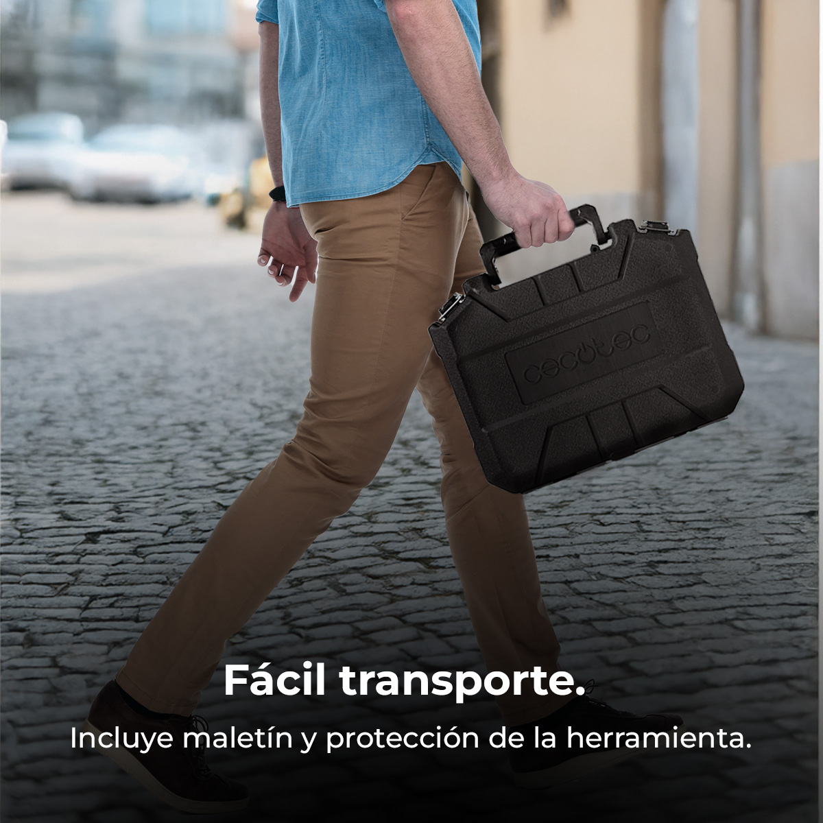 Hombre lleva maletín negro con asa. Viste vaqueros y camisa azul.