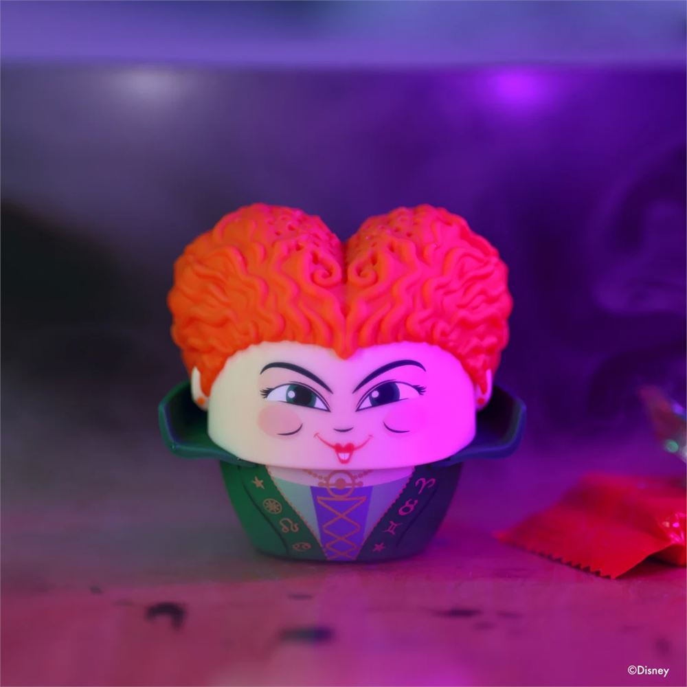 Turuncu saçlı, cupcake'e benzeyen yüzlü karakter, mor ışıklandırmada.