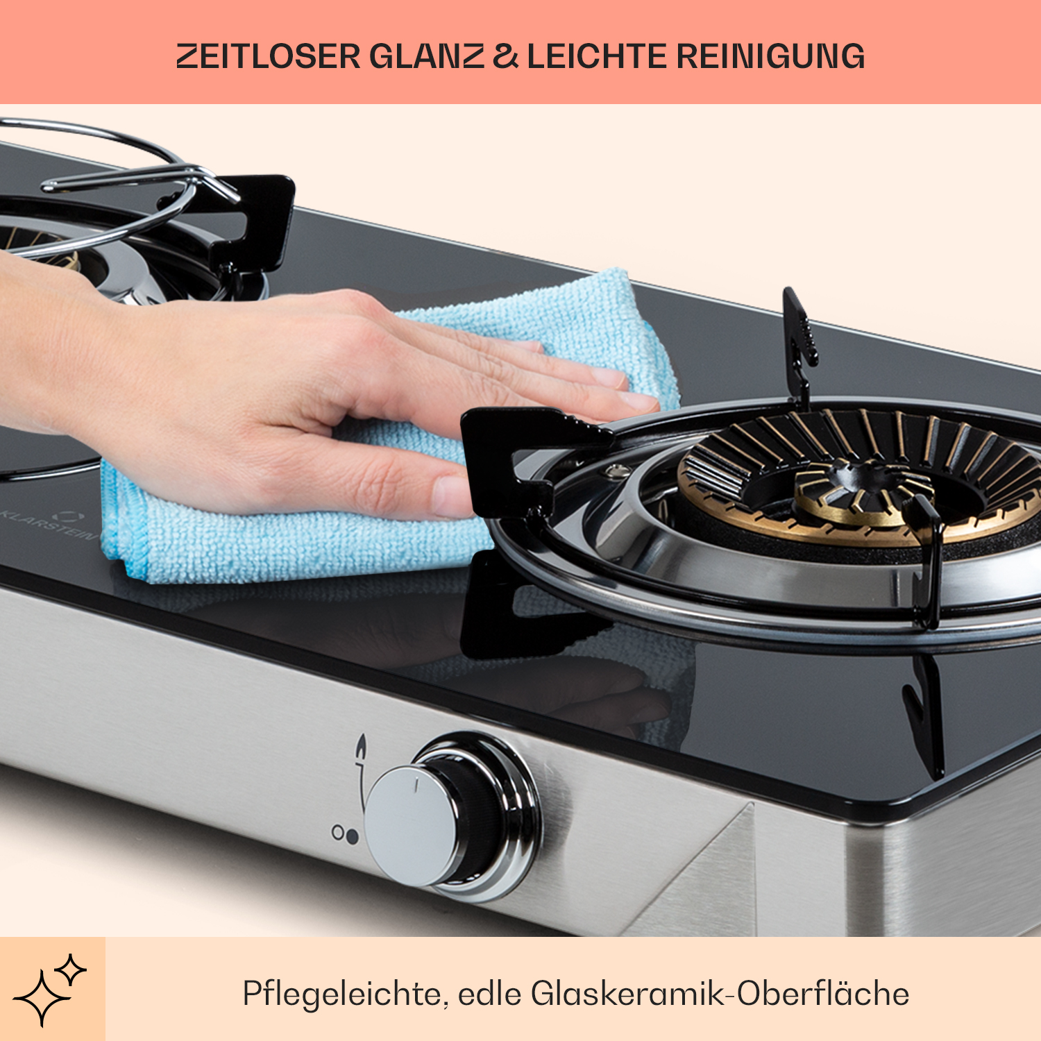 Eine Hand wischt mit einem blauen Tuch über die Kochfeld-Oberfläche.