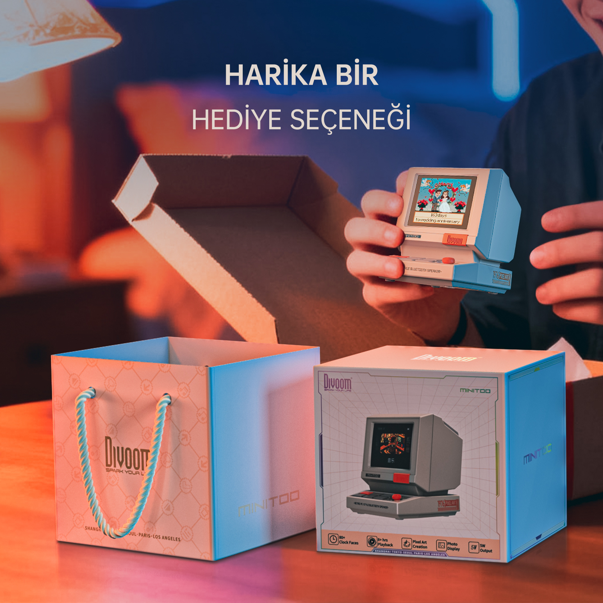 Bir adam hediye kutusunun yanında stilize edilmiş mini bilgisayar paketinden çıkarıyor.