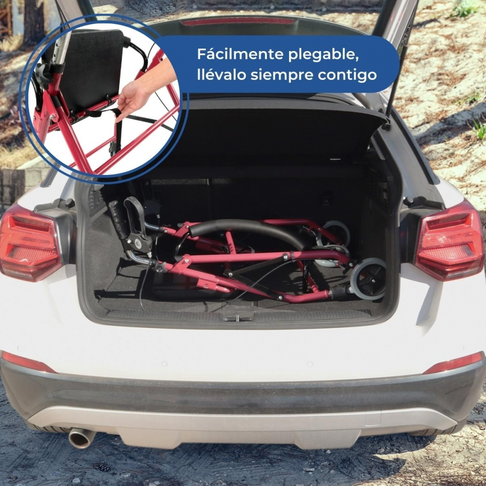 Un andador rojo plegado está en el maletero de un coche blanco.