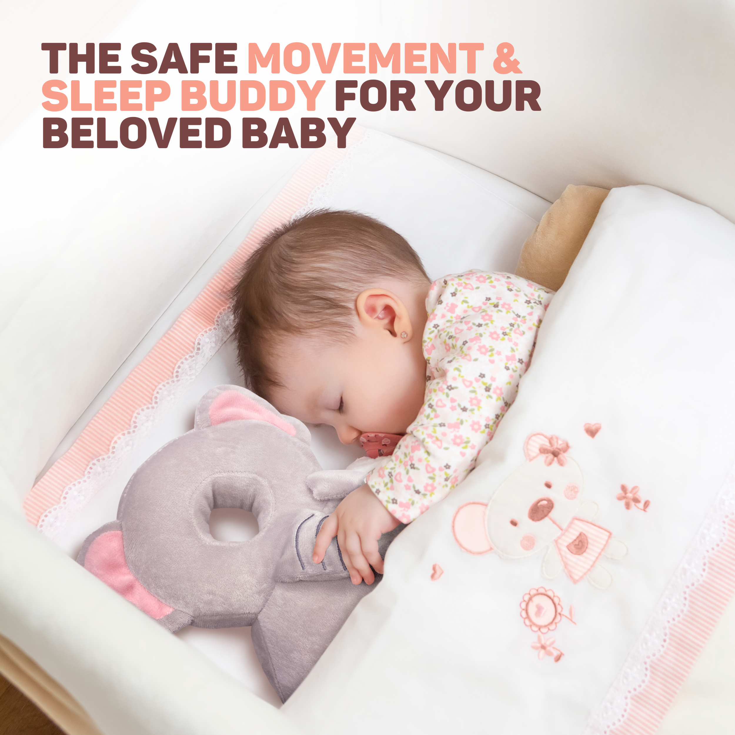 Een baby slaapt in een wieg met een olifantenkussen en deken.