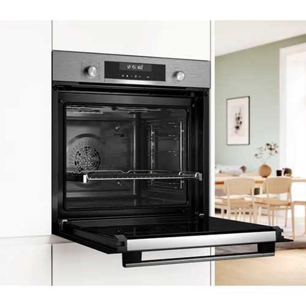 Un horno empotrado moderno con la puerta abierta en una cocina.