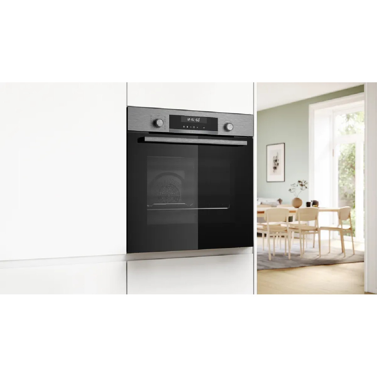 Horno empotrado moderno aspecto acero inoxidable junto a comedor.