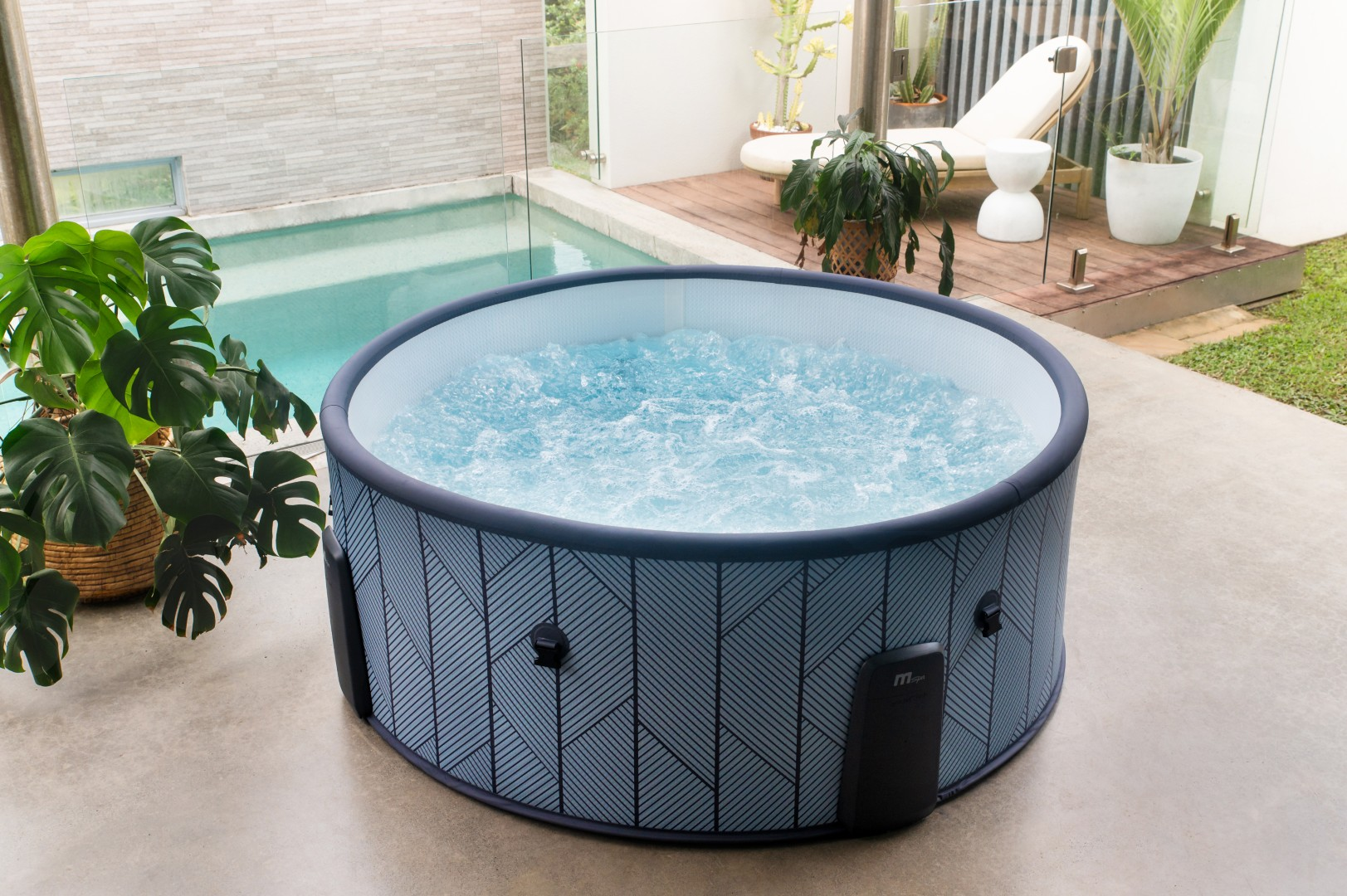 Aufblasbarer Whirlpool mit sprudelndem Wasser und Pflanzen neben einem Pool.