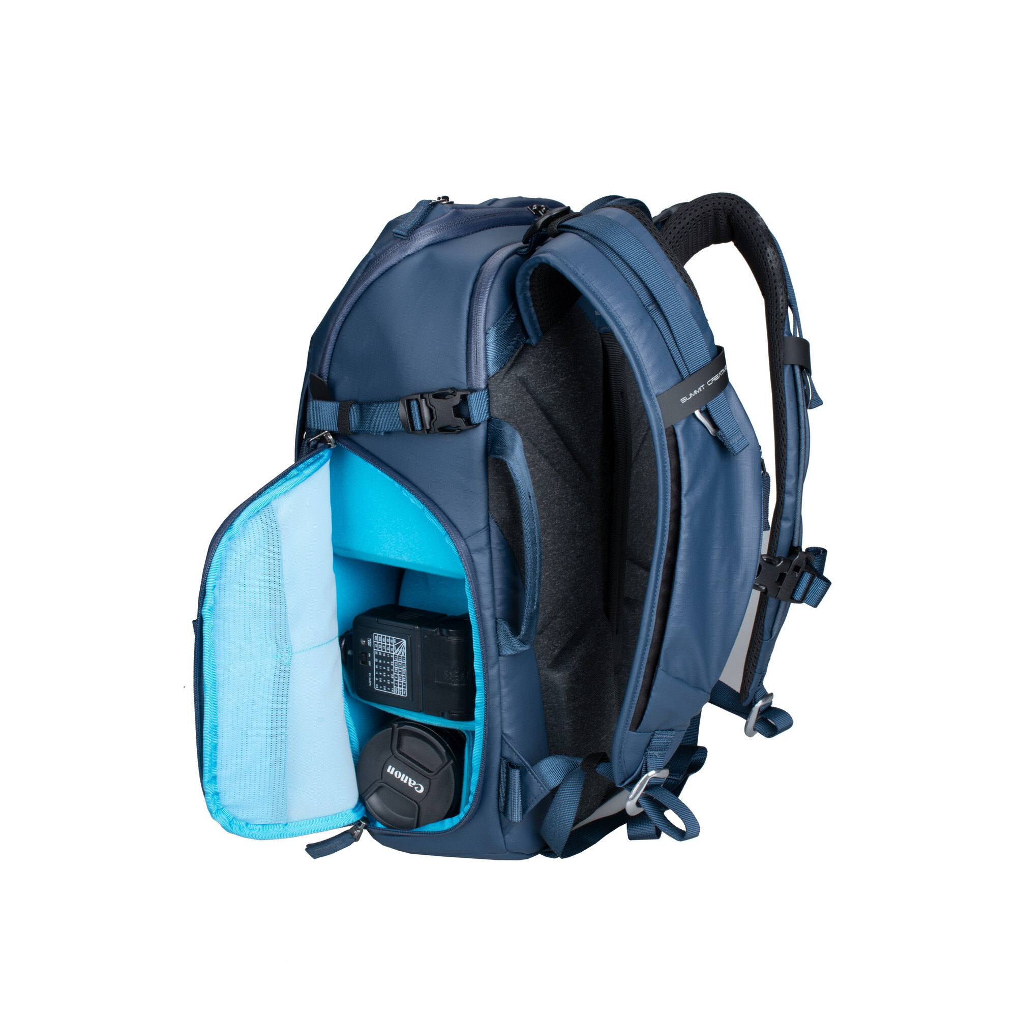 Blauer Rucksack mit geöffnetem Fach, enthält Kamera und Objektivdeckel.