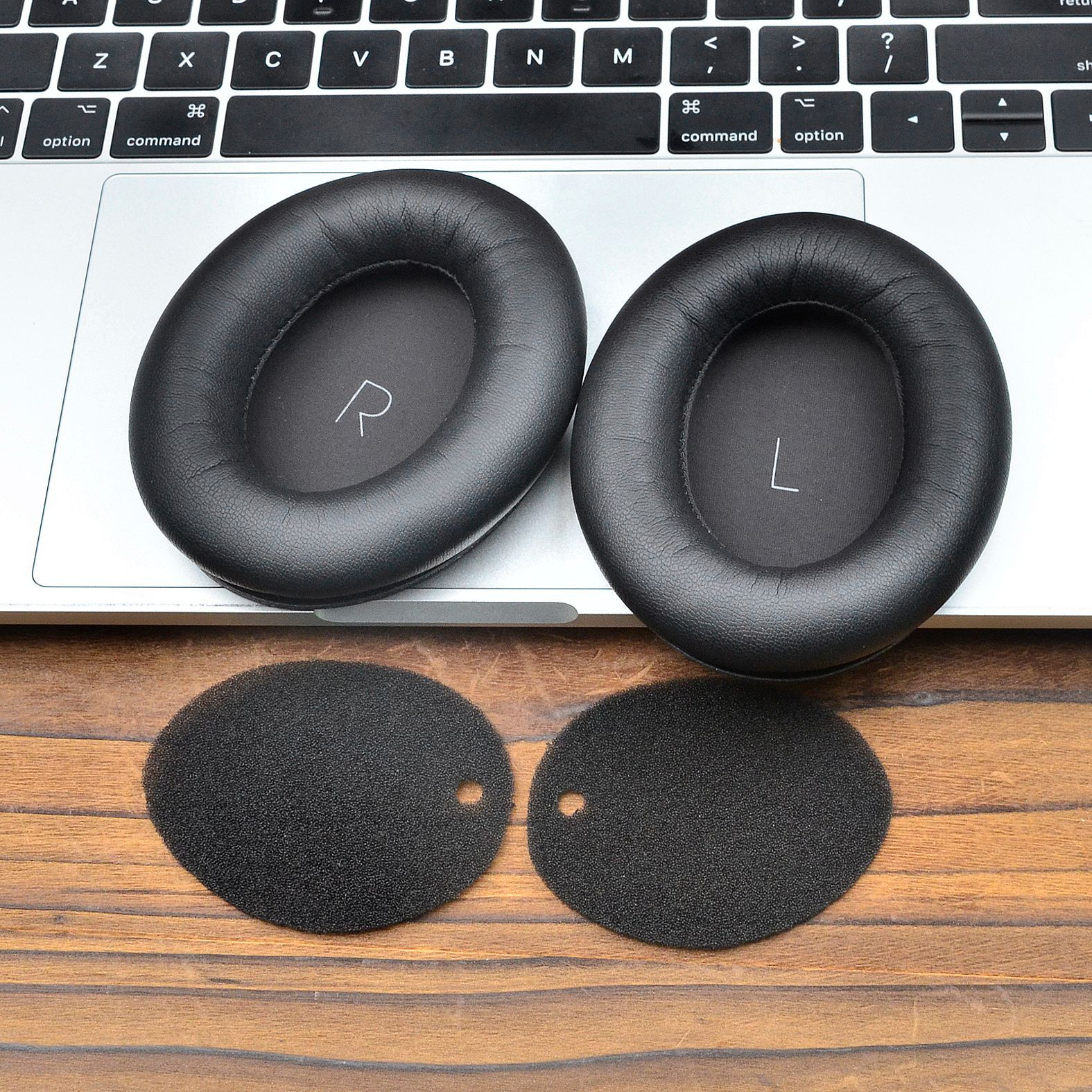Coussinets d'oreille noirs avec marquage R/L sur un ordinateur portable, avec inserts en mousse dessous.