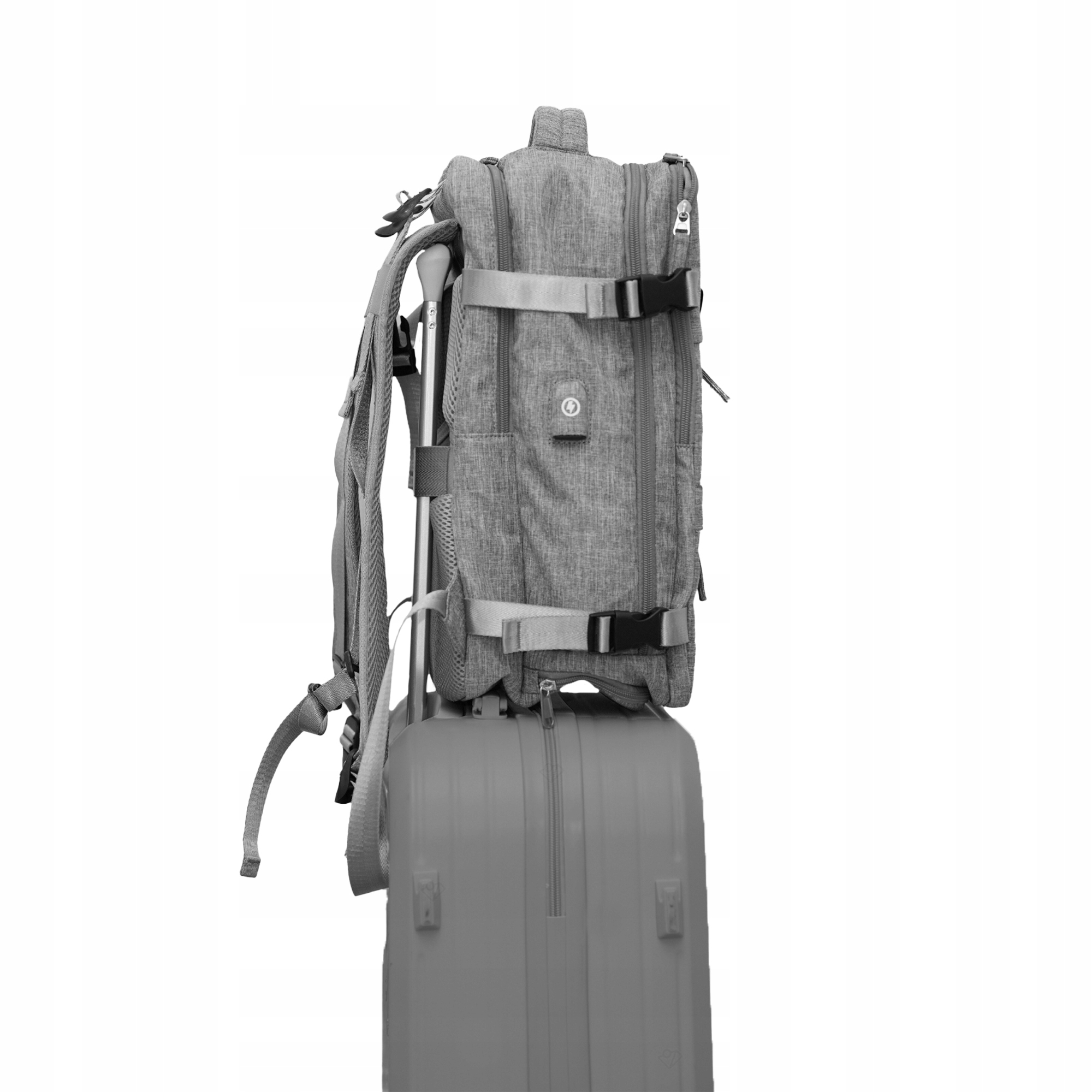 Szary plecak na szarej walizce na białym tle.