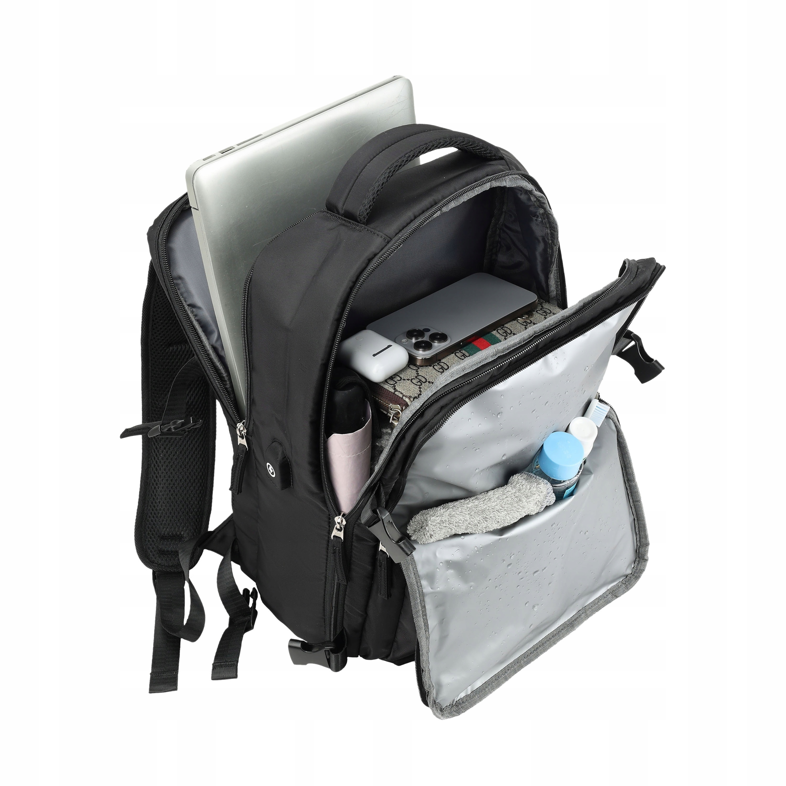 Otwarty czarny plecak z laptopem, telefonem, słuchawkami i kosmetykami.