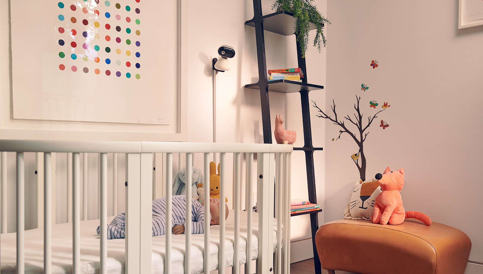 Baby im Gitterbett mit Spielzeug, Kunst und Wanddeko.