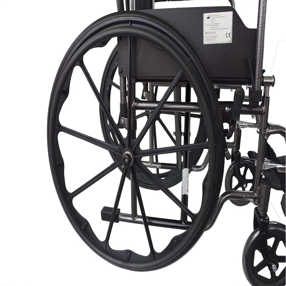 Una rueda negra de silla de ruedas con radios y neumático. El resto de la silla de ruedas es visible al fondo.