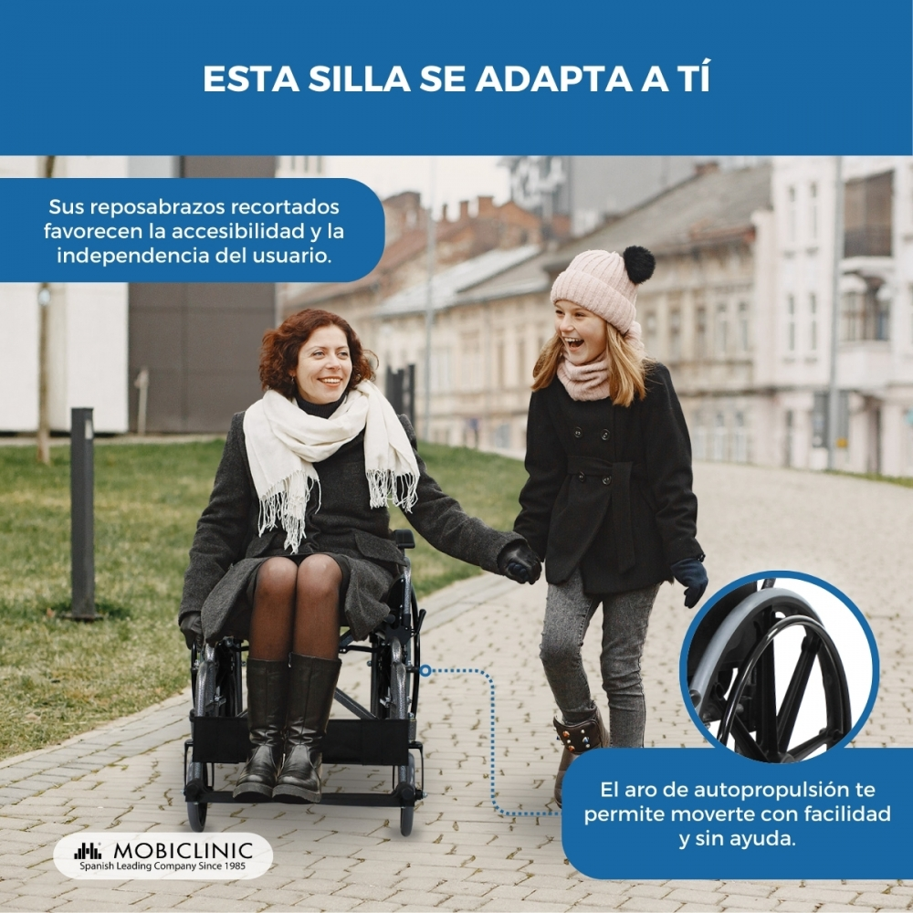 Una mujer en silla de ruedas pasea con una niña por la calle.
