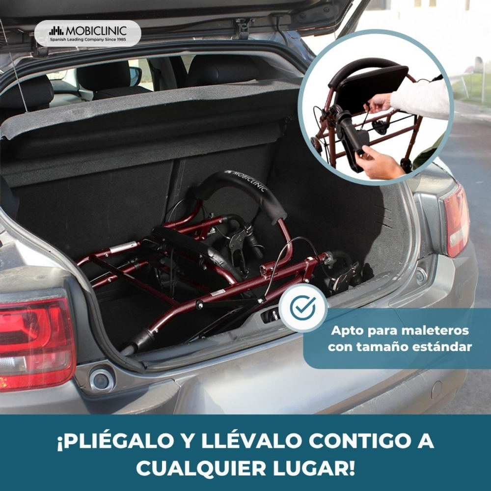 Un andador rojo plegado está en el maletero de un coche.