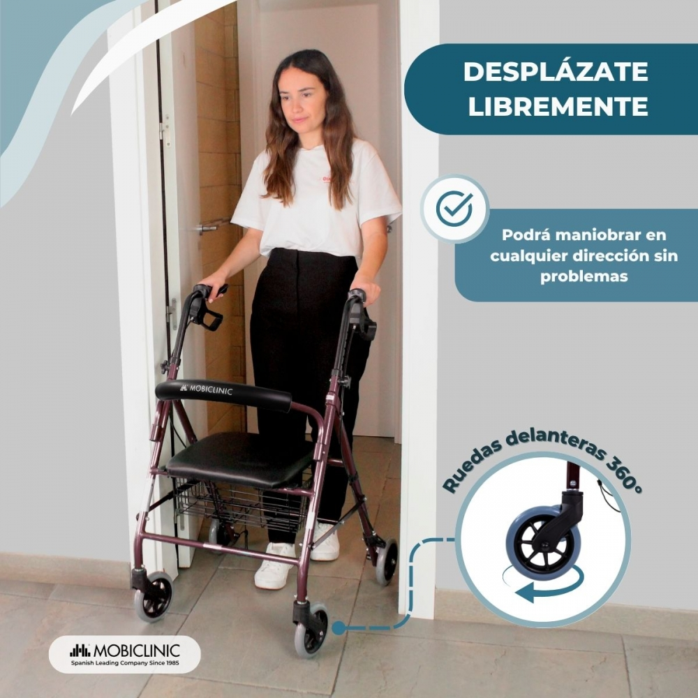 Una mujer con un andador morado está de pie en un umbral. Tiene ruedas y asiento.
