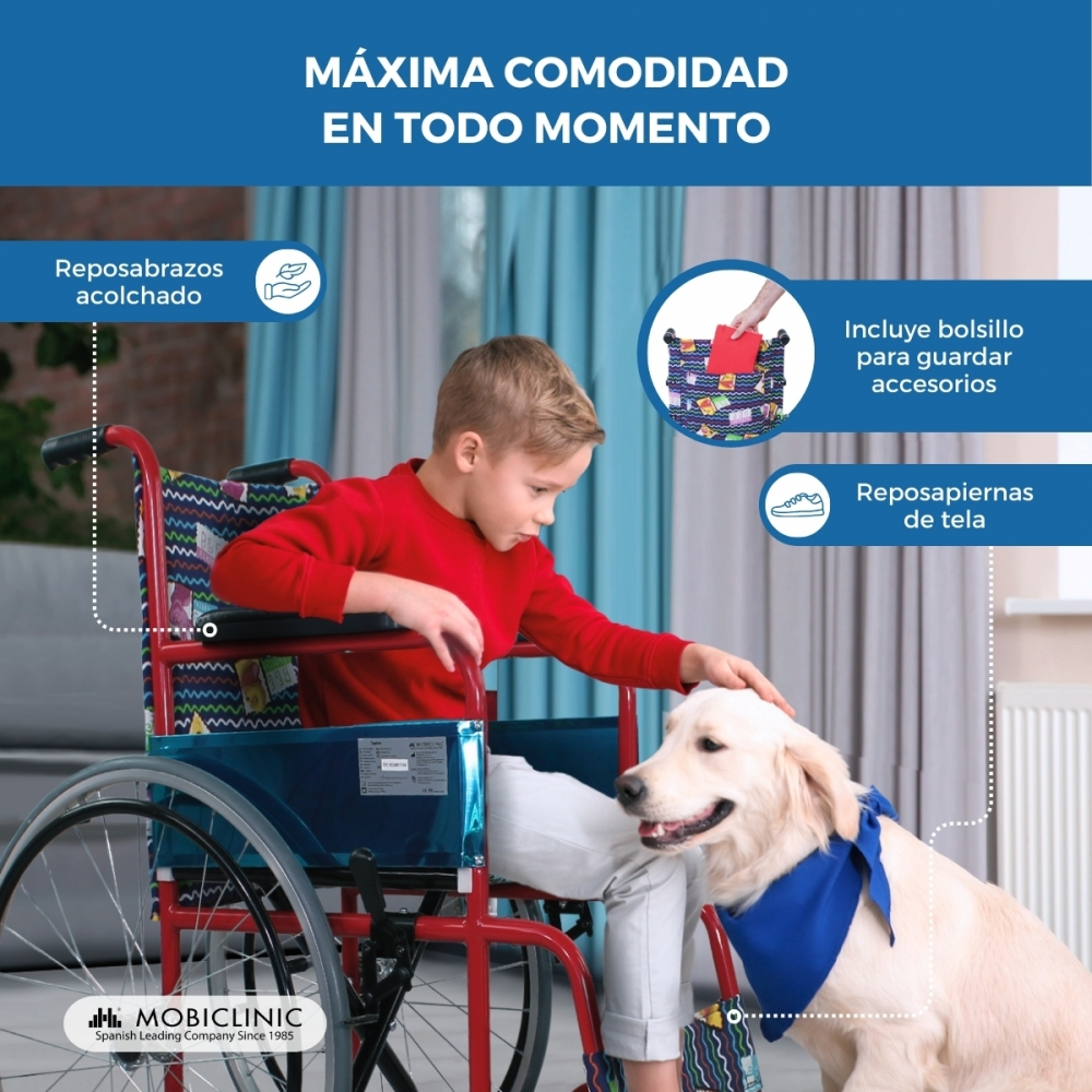 Un niño en silla de ruedas acaricia a un perro. La silla tiene reposabrazos y reposapiés de tela.