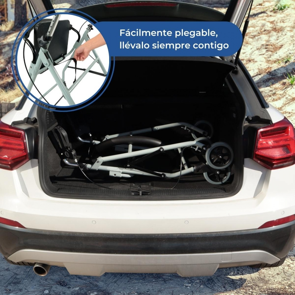 Un andador plegado está en el maletero de un coche blanco.