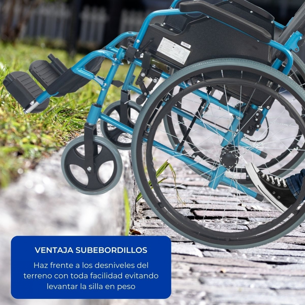 Una silla de ruedas azul-turquesa sube un bordillo, se ve un pie con zapato.