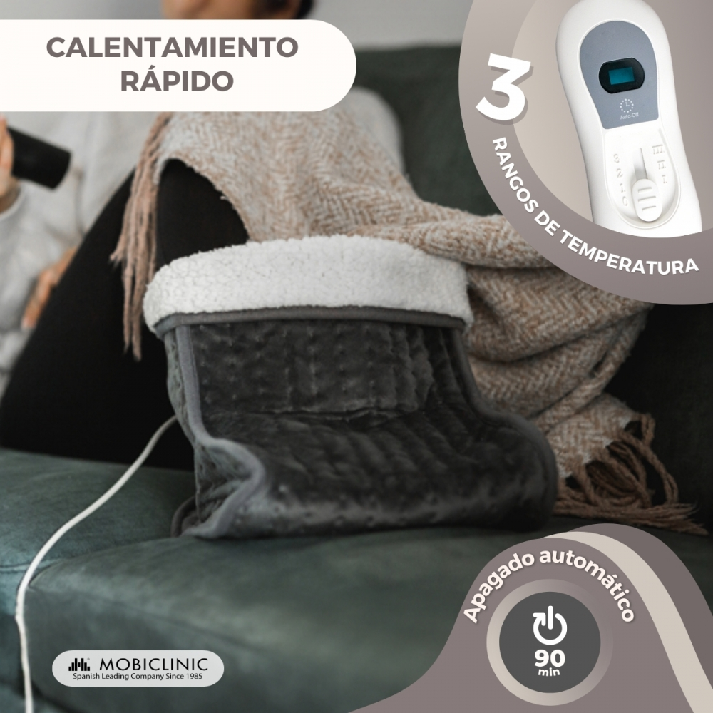 Calentador de pies eléctrico gris con forro de pelo blanco en un sofá.